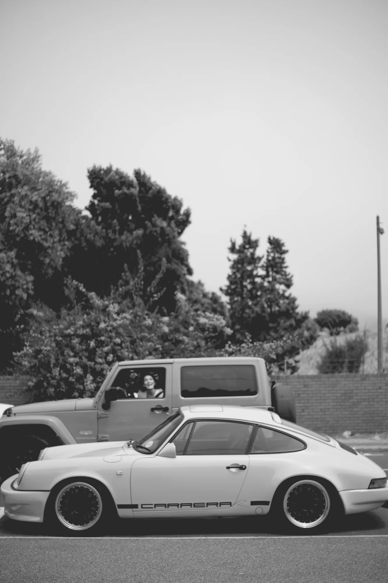 2022-02-18 - Cape Town - Porsche parked with person driving in a jeep shouting out of window